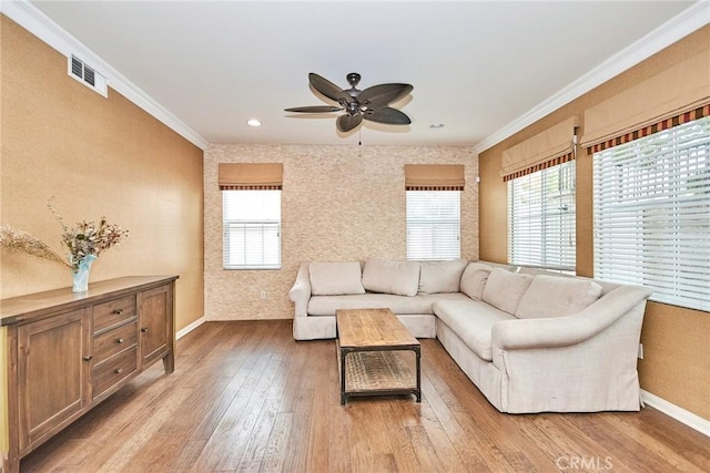 living room featuring light hardwood / wood-style floors, ceiling fan, and crown molding