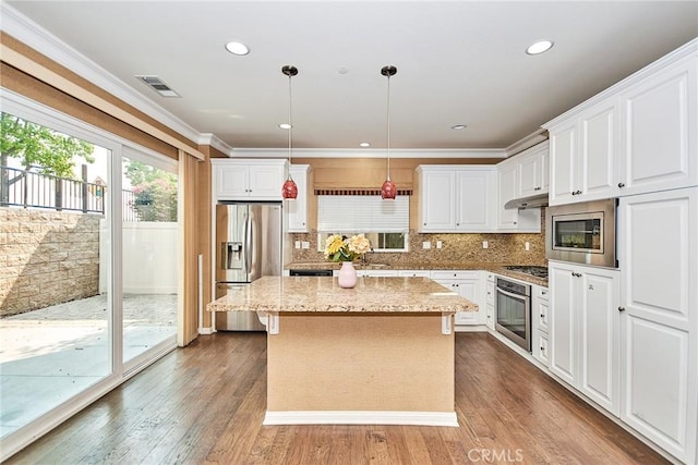 kitchen with light stone counters, stainless steel appliances, pendant lighting, wood-type flooring, and a center island