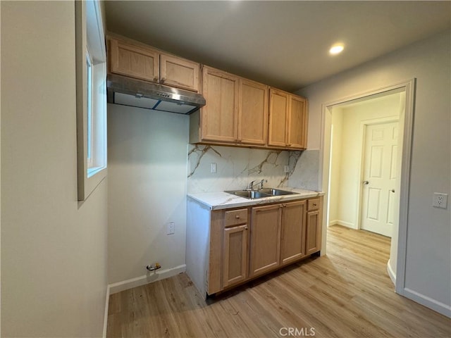 kitchen with decorative backsplash, sink, and light hardwood / wood-style flooring