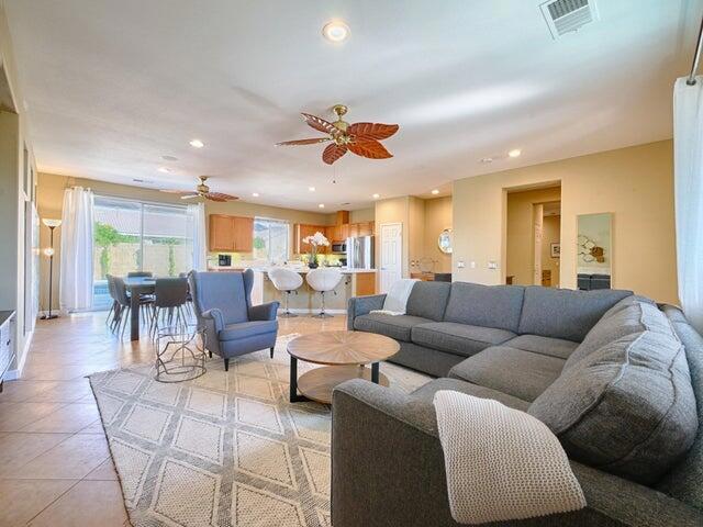 living room with light tile patterned floors and ceiling fan