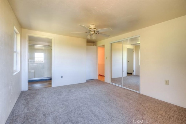 unfurnished bedroom with ceiling fan, carpet floors, a closet, and connected bathroom