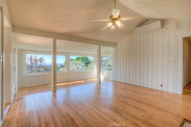 interior space featuring lofted ceiling, wood finished floors, ceiling fan, and a wall mounted AC