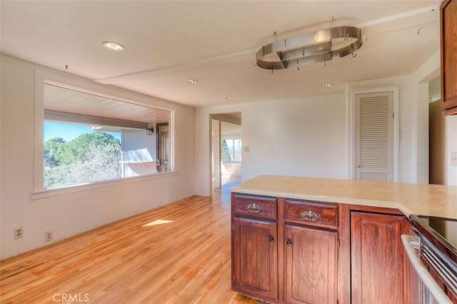 kitchen featuring brown cabinets, light wood-style floors, and light countertops