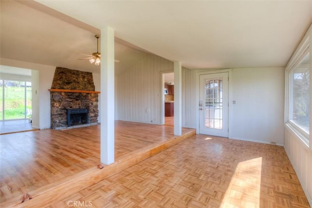 unfurnished living room with a fireplace, ceiling fan, and parquet flooring