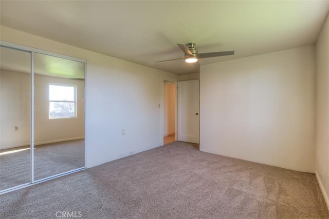 unfurnished bedroom with ceiling fan, carpet floors, and a closet