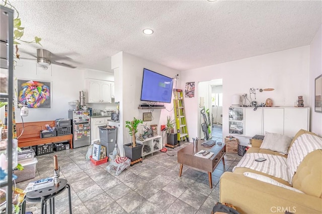 living room featuring a textured ceiling and ceiling fan