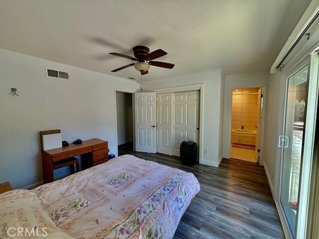 bedroom with multiple windows, dark hardwood / wood-style floors, ceiling fan, and a closet