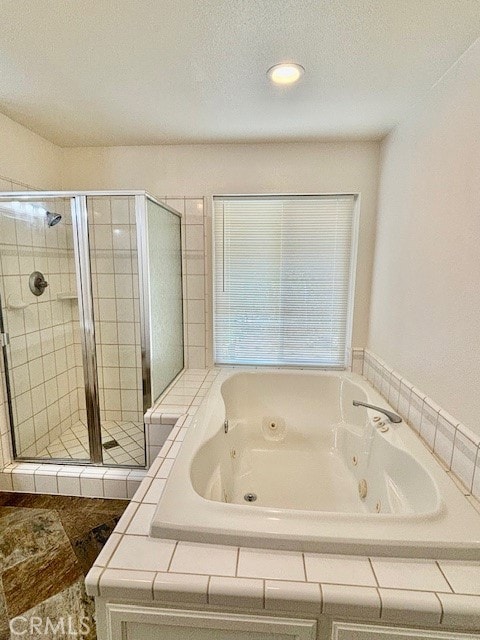 bathroom featuring a textured ceiling and plus walk in shower