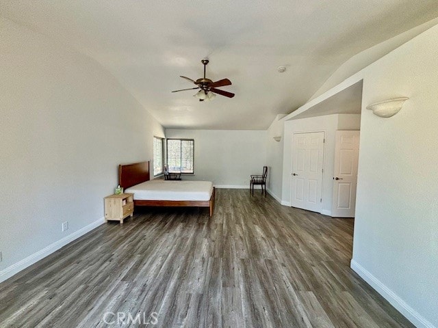 unfurnished bedroom with vaulted ceiling, dark hardwood / wood-style flooring, and ceiling fan