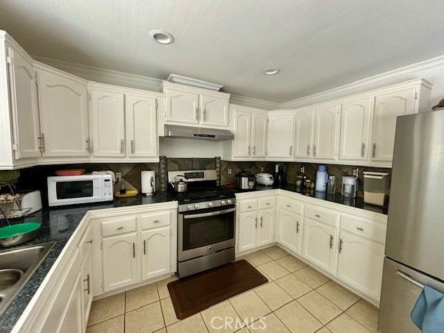 kitchen with appliances with stainless steel finishes, crown molding, backsplash, and white cabinetry