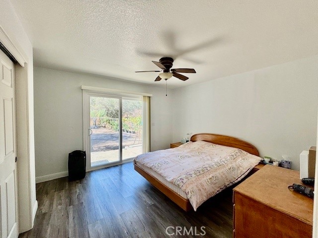 bedroom with access to outside, ceiling fan, a textured ceiling, a closet, and dark hardwood / wood-style flooring