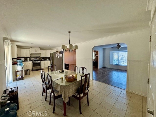 dining room with ceiling fan with notable chandelier, light hardwood / wood-style floors, and ornamental molding