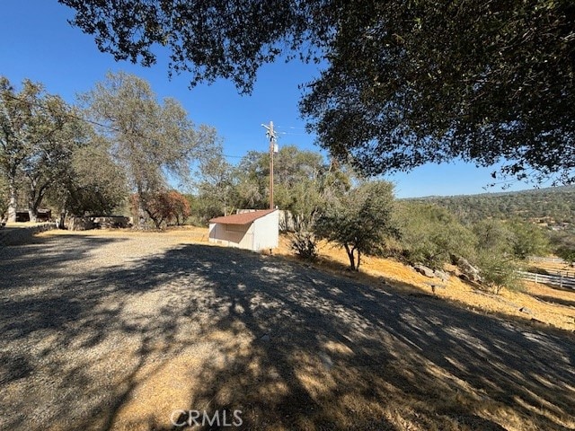 view of yard with a rural view and an outbuilding