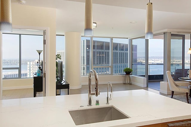 kitchen featuring a water view, sink, and light stone counters