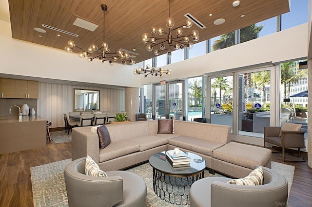 living room with a wealth of natural light, sink, hardwood / wood-style flooring, a notable chandelier, and wood ceiling