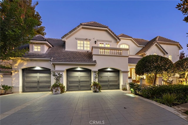 mediterranean / spanish-style home with a garage and a balcony