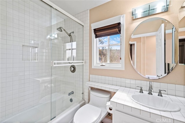 full bathroom featuring vanity, toilet, and bath / shower combo with glass door