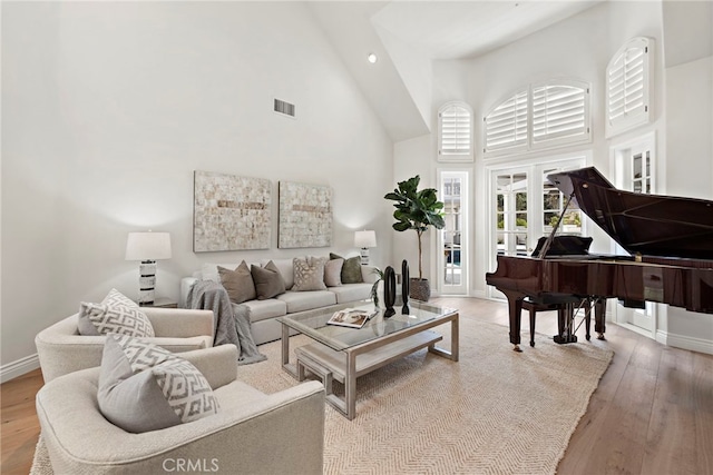 living room featuring a high ceiling and light hardwood / wood-style flooring