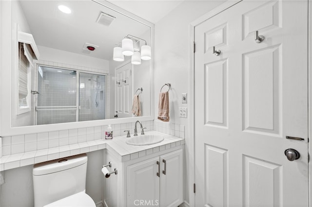 bathroom with backsplash, vanity, and toilet