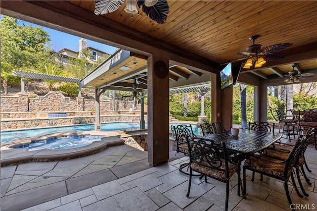 view of patio / terrace featuring ceiling fan and a pool with hot tub