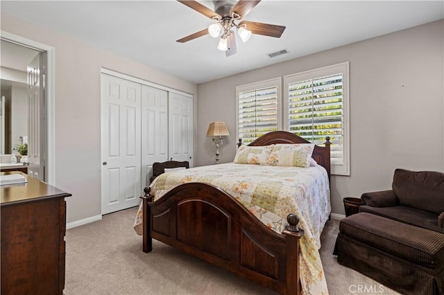 bedroom featuring ceiling fan, a closet, and light colored carpet