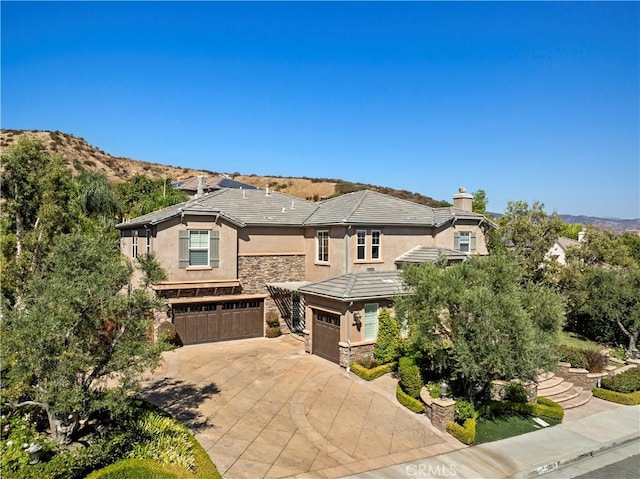 view of front of home with a mountain view and a garage