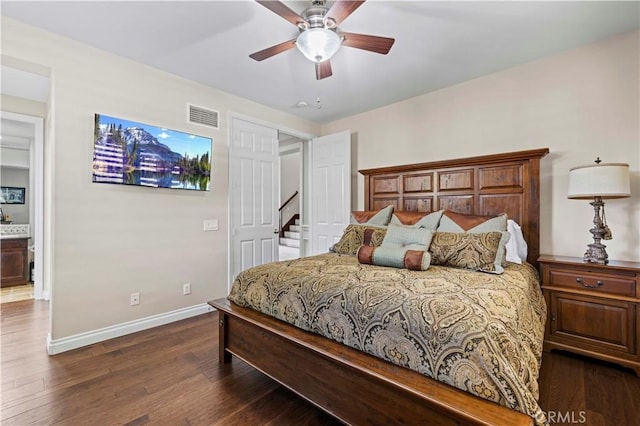 bedroom featuring ensuite bath, ceiling fan, and dark wood-type flooring