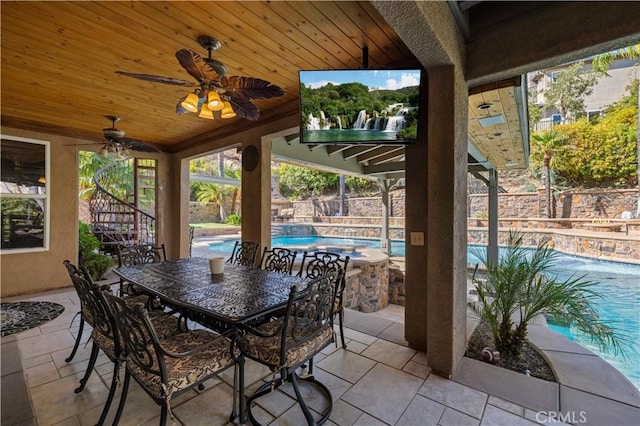 view of patio featuring a swimming pool with hot tub and ceiling fan