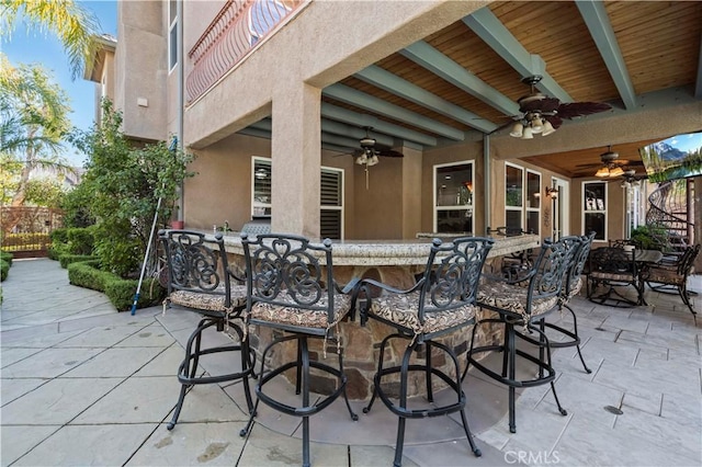 view of patio / terrace with ceiling fan and a bar