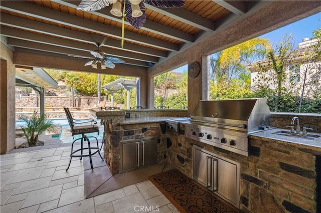 view of patio / terrace with ceiling fan, a grill, a wet bar, and area for grilling