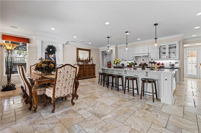 dining area featuring a wealth of natural light, crown molding, and sink