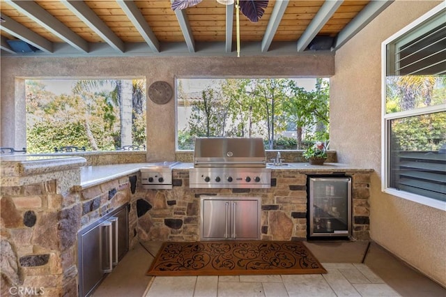 view of patio featuring area for grilling, exterior kitchen, sink, and beverage cooler