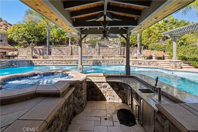 view of pool featuring pool water feature, ceiling fan, and sink