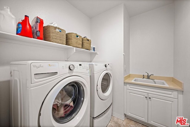 laundry room with cabinets, sink, and washer and dryer