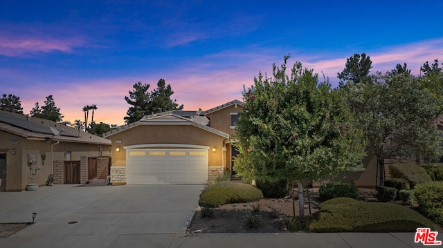 view of front of property featuring a garage and solar panels