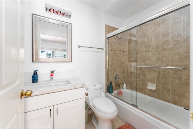 full bathroom with shower / bath combination with glass door, vanity, toilet, and tile patterned floors