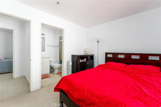 bedroom with light colored carpet and ensuite bathroom