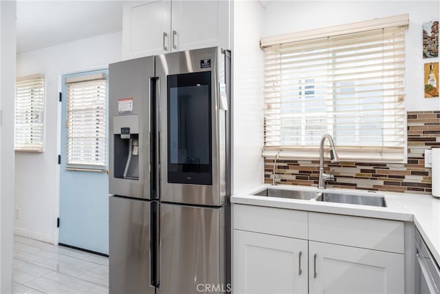 kitchen featuring stainless steel appliances, sink, tasteful backsplash, and white cabinetry