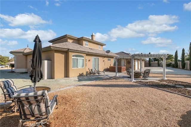 back of house featuring a pergola, a patio area, and a jacuzzi