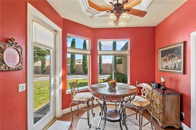 dining area with crown molding, ceiling fan, hardwood / wood-style flooring, and a healthy amount of sunlight