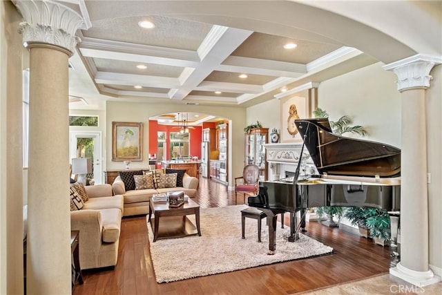 living area with coffered ceiling, ornamental molding, beamed ceiling, and ornate columns