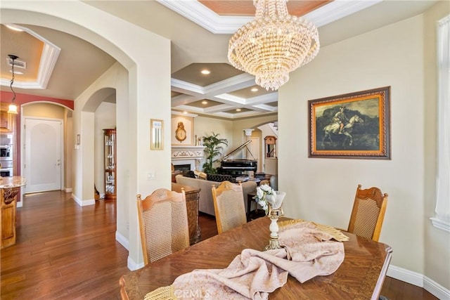 dining area with dark hardwood / wood-style floors, beamed ceiling, a chandelier, ornamental molding, and coffered ceiling