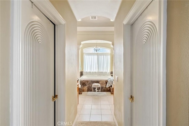 hallway featuring light tile patterned flooring and lofted ceiling