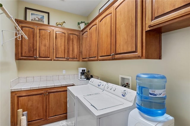 washroom with cabinets and washing machine and clothes dryer