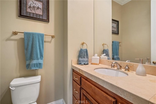 bathroom featuring vanity, crown molding, and toilet