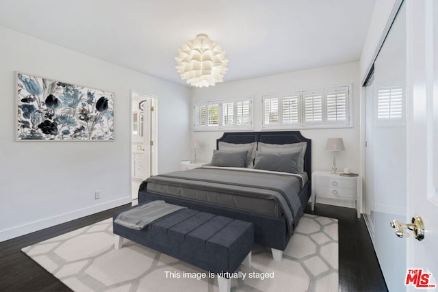 bedroom with hardwood / wood-style floors and ensuite bathroom