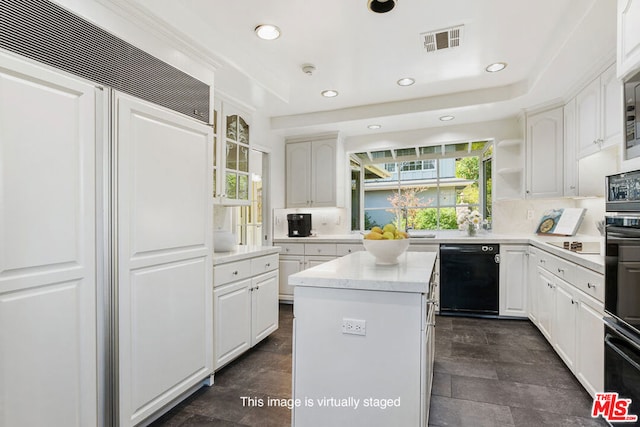 kitchen with a kitchen island, backsplash, black appliances, and white cabinets