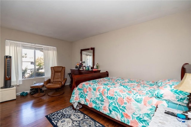 bedroom with wood finished floors and baseboards