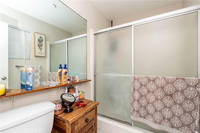 bathroom featuring toilet and a stall shower