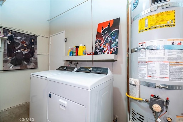 laundry room with strapped water heater, washing machine and clothes dryer, and laundry area